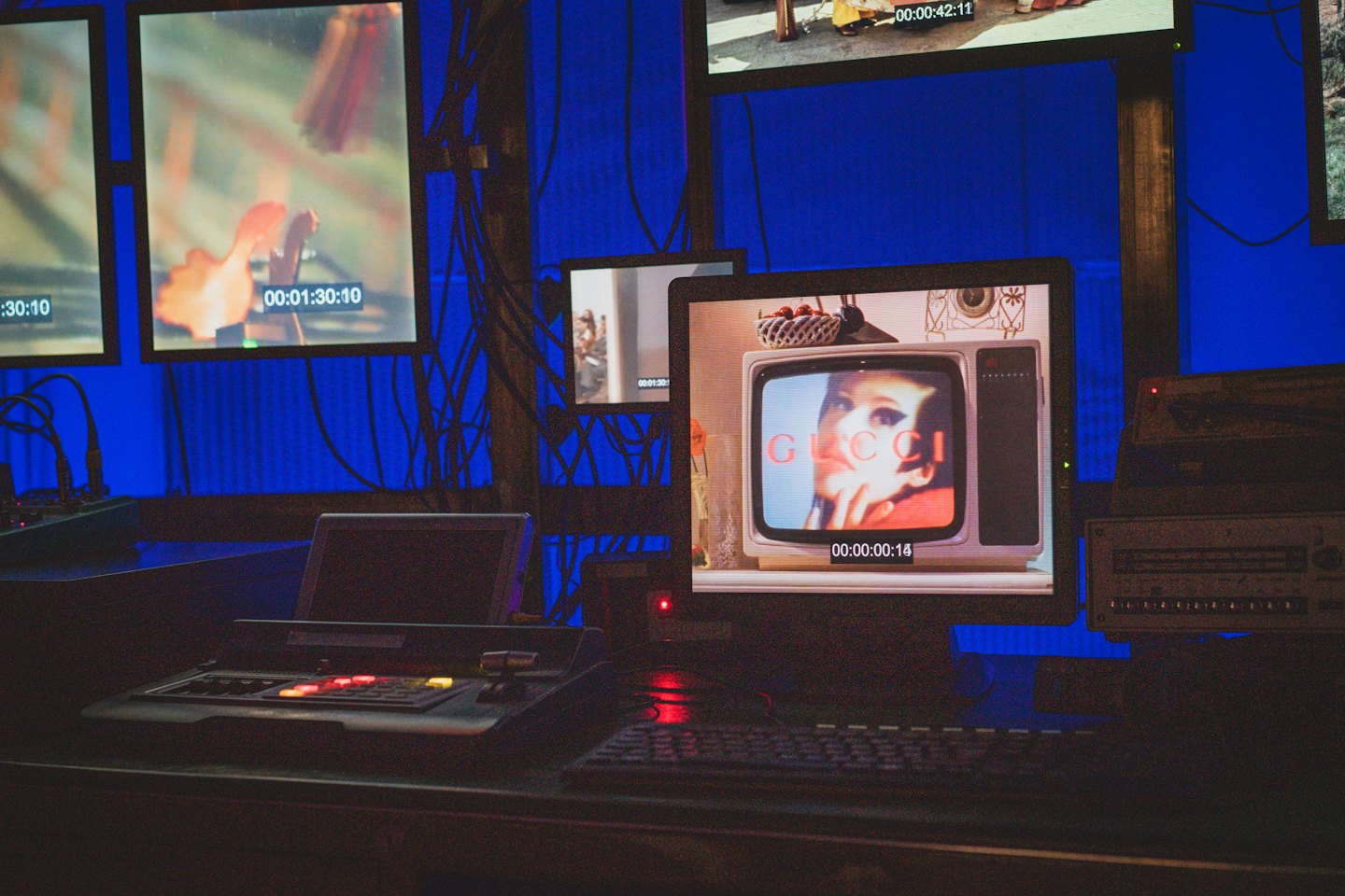 Video editing suite with monitors showing feeds and a woman's face.